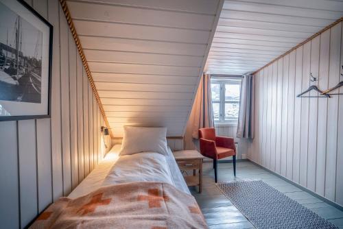 Habitación pequeña con cama y silla en Nyvågar Rorbuhotell - by Classic Norway Hotels, en Kabelvåg