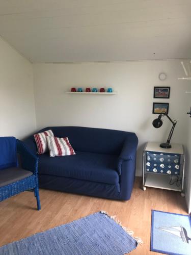 a living room with a blue couch and a table at Villa Sus & Dus in Yngsjö