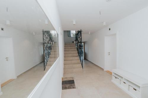 a staircase in a house with white walls and white floors at Apartments Trifunovic Old Town in Budva