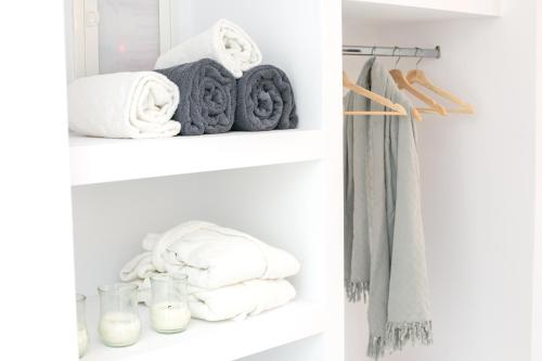 a white closet with towels on shelves at Apanomeria Boutique Residence in Oia