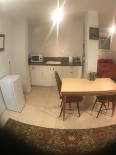 a kitchen with a table and chairs in a room at Magnificant Studio/Zimmer Zichron in Zikhron Ya‘aqov