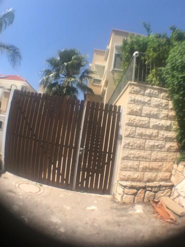 a wooden fence in front of a house at Magnificant Studio/Zimmer Zichron in Zikhron Ya‘aqov