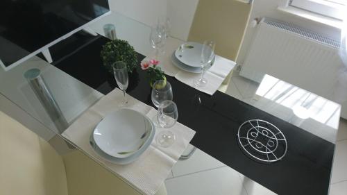 einen Esstisch mit 2 Tellern und Weingläsern in der Unterkunft Apartment City in Radolfzell am Bodensee