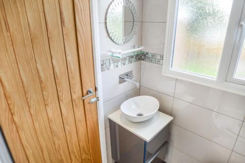 a bathroom with a toilet and a sink and a window at Romney House in Hythe