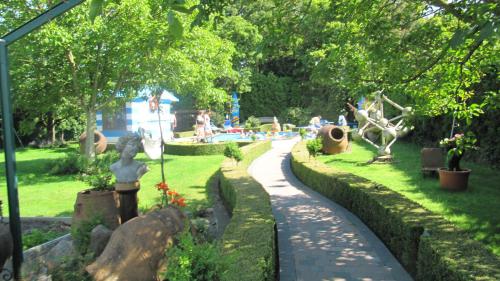 a garden with people sitting in a park at B&B Casa Roman & Vakantiewoning voor 1 pers tot max 32 personen in Zonhoven