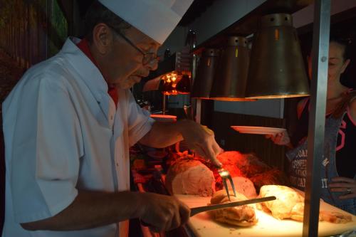 a chef preparing food in a restaurant kitchen at Antonis G. Hotel Apartments in Voroklini