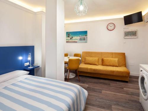 una camera con letto, divano e tavolo di Duende RooMalaga by Bossh! Apartments a Málaga