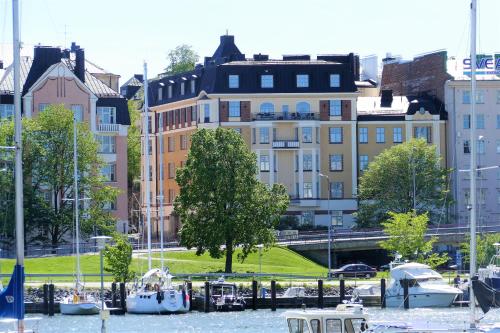 a group of boats in the water near buildings at Kruna by the Sea in Helsinki