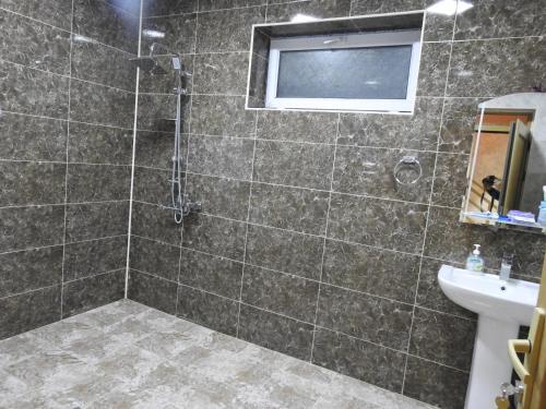 ein Bad mit einer Dusche und einem Waschbecken in der Unterkunft Gabala Sweet Home in Qəbələ