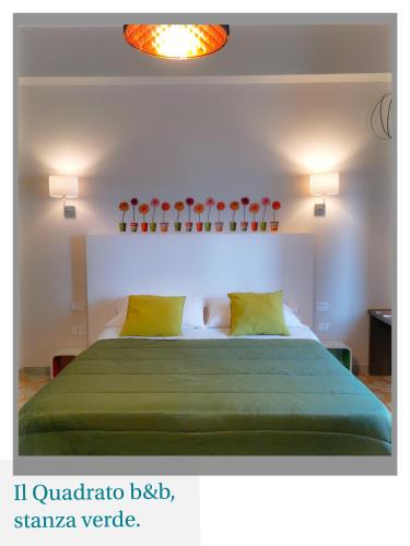 a bedroom with a large bed with a green blanket at Il Quadrato Bed and Breakfast in Marina di Schiavonea