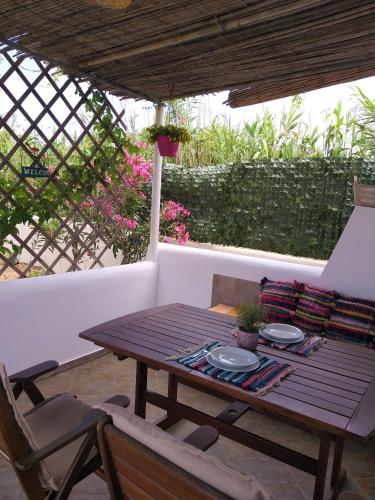 a wooden table and a chair on a patio at Michaella Studios in Plaka