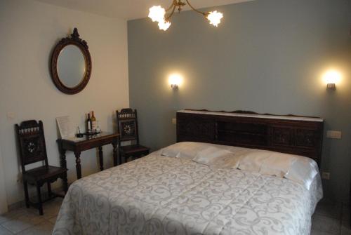 a bedroom with a bed and a mirror and two chairs at B&B Casa Roman & Vakantiewoning voor 1 pers tot max 32 personen in Zonhoven
