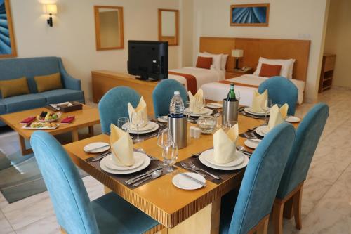 a dining room with a table and blue chairs at City Seasons Hotel & Suites Muscat in Muscat