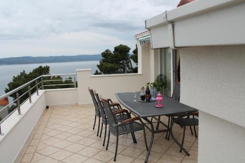 a patio with a table and chairs on a balcony at Apartments Tomas in Brela