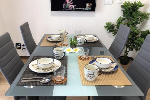 a dining room table with two chairs and a table with cups and plates at TerraceRin YN33 in Tomigusuku