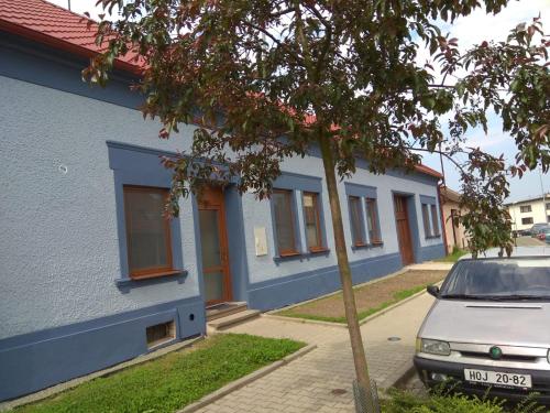 a blue building with a car parked in front of it at Apartmány U splavu in Veselí nad Moravou
