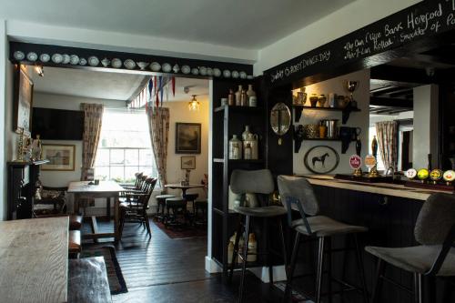 um bar num restaurante com mesa e cadeiras em The Carden Arms em Tilston