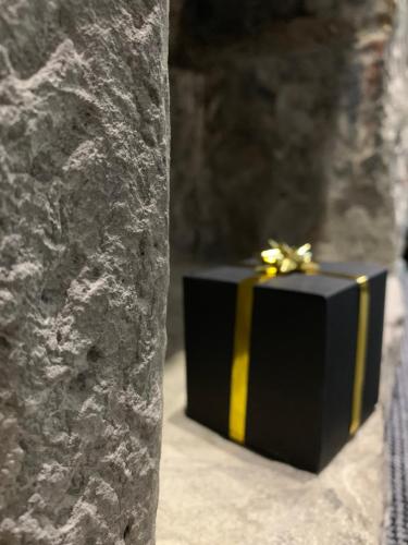 a black gift box sitting next to a stone wall at Royal Mile Suites by the Castle in Edinburgh