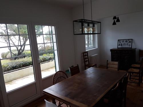 une salle à manger avec une table et des chaises en bois dans l'établissement La Villa Fuberia - Seafront Bassin d'Arcachon, à Pyla-sur-Mer