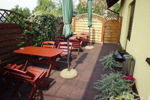 a patio with tables and chairs and an umbrella at Mączne Skały in Biały Kościół