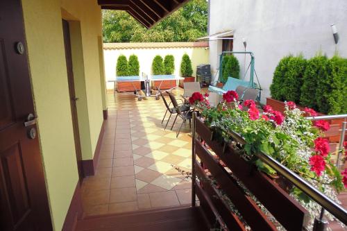 a balcony with red flowers and a table and chairs at Mączne Skały in Biały Kościół