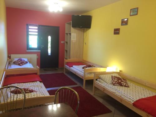a room with four beds and a tv on the wall at Mączne Skały in Biały Kościół