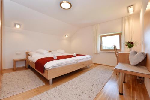 a bedroom with a bed and a window and a chair at Hof Lässer in Möggers