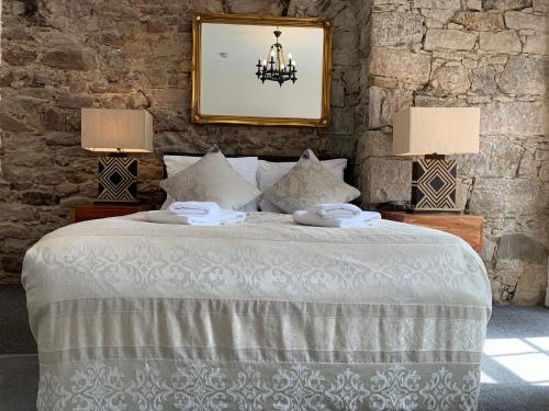 a bedroom with a white bed with two lamps at Royal Mile Suites by the Castle in Edinburgh
