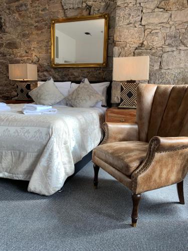 a bedroom with a bed and a chair and a mirror at Royal Mile Suites by the Castle in Edinburgh