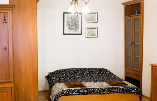 a small bedroom with a bed and a wooden cabinet at D&A Apartments Szewska in Krakow