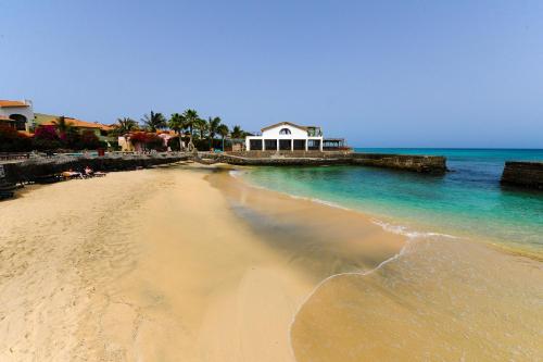 a beach with a house and the ocean at Porto Antigo Top 10 in Santa Maria