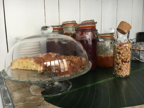 a cake on a glass plate on a counter with jars at Ô 36 Rempart Sud B&B in Aigues-Mortes