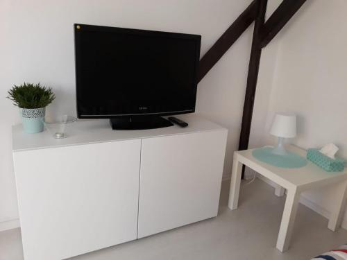telewizor na górze białej szafki w pokoju w obiekcie Apartament Mariacka w Bydgoszczy