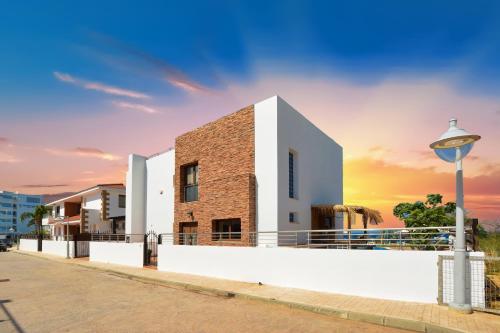 a building on a street with a sunset in the background at Seafront Protaras Villas in Protaras
