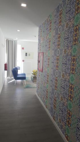 a hallway with a blue chair and a wall at Hotel Sol Algarve by Kavia in Faro