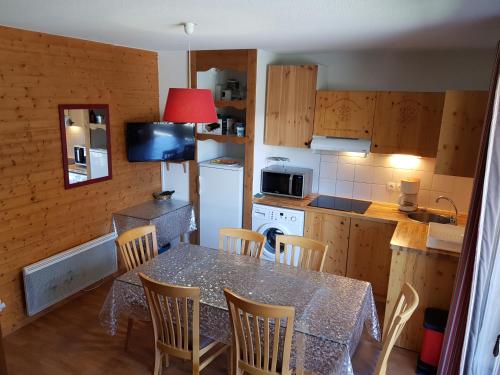 a kitchen with a table and chairs and a kitchen with a refrigerator at Montagne Duplex-Orelle 9 pers. avec SPA in Orelle