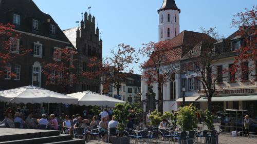 a group of people sitting under umbrellas on a city street at Ferienwohnung Kriemhild in Xanten