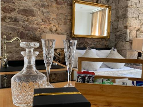 1 dormitorio con 1 cama y 2 copas de vino en una mesa en Royal Mile Suites by the Castle en Edimburgo