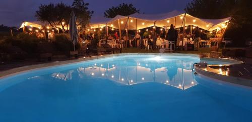 a swimming pool with lights in front of a marquee at Domaine De Pradaous in Reillanne