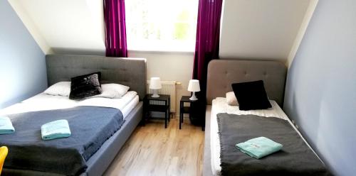 a small room with two beds and a window at Great Polonia Beach & Molo in Puck