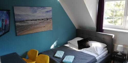 a small bedroom with a bed and a window at Great Polonia Beach & Molo in Puck