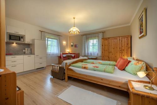 a bedroom with a large bed and a kitchen at Urlaub am Lacknerhof - Familie Klocker in Liebenfels