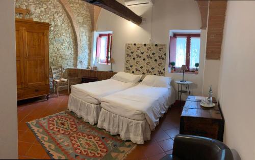 a bedroom with a large bed and a table at Farmhouse B&B Il Paretaio in Barberino di Val dʼElsa