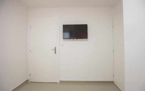 two white cabinets with a television on top of them at Pansion Kipovi in Tuzla