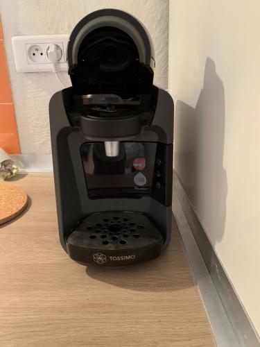 a black coffee maker sitting on a table at La garde Studio atypique Le Rocher, climatisation, belle décoration in La Garde