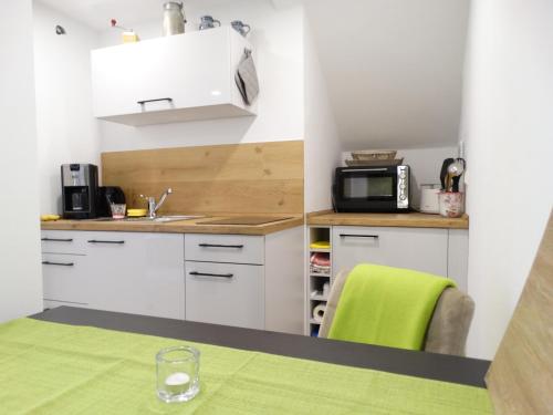 a small kitchen with a table and a microwave at Kleines Moselchalet in Cochem