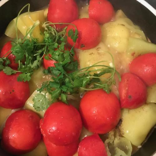 a pot of soup with tomatoes and potatoes and parsley at Christy Hotel in Goris