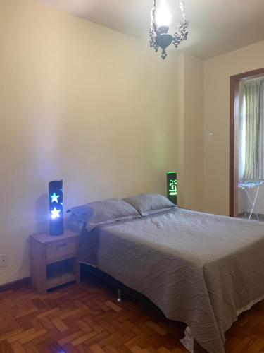 a bedroom with a bed and a lamp on a night stand at 4 bedroom at the beach in Rio de Janeiro