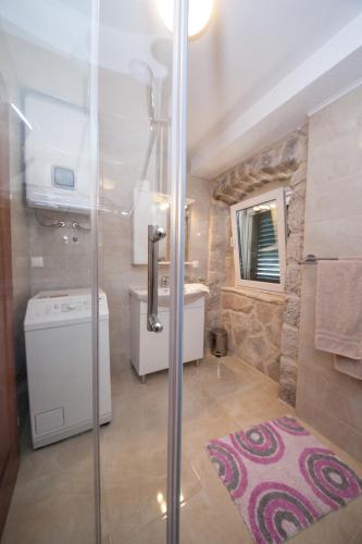 a bathroom with a shower and a sink and a toilet at VILLA FENIX PODGORA in Podgora