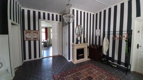 a hallway with black and white striped walls and a fireplace at Geijersholms Herrgård in Hagfors